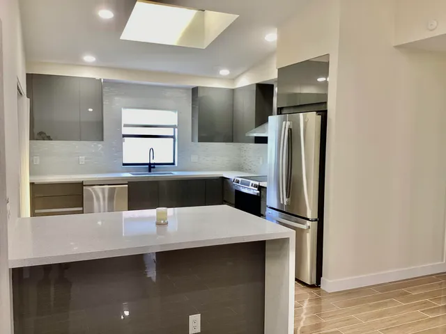 a kitchen with stainless steel appliances a refrigerator and a counter top space