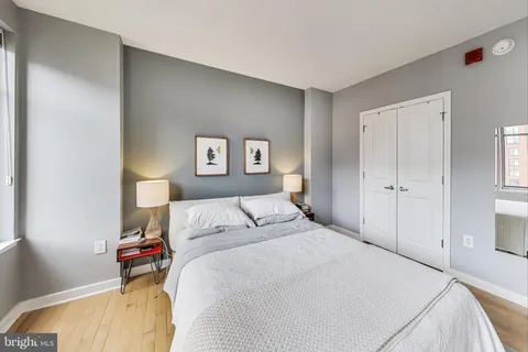 a bedroom with a bed and a painting on the wall