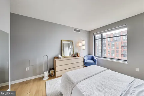 a bedroom with a bed and wooden floor