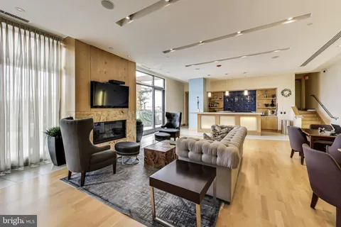 a living room with furniture flat screen tv and large window