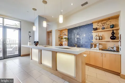 a large kitchen with kitchen island a sink a stove a refrigerator and white cabinets next to a window