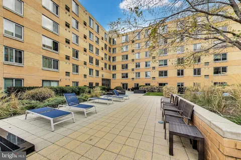 a view of a patio with a table and chairs and wooden fence