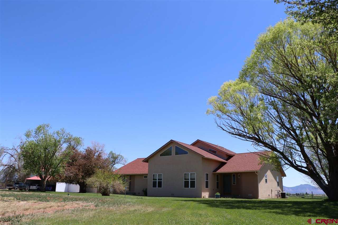 23720 County Rd M Cortez, CO 81321 - Photo 2 of 34 a front view of a house with a garden and trees
