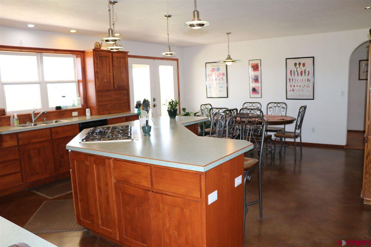 23720 County Rd M Cortez, CO 81321 - Photo 28 of 34 a kitchen with stainless steel appliances granite countertop a sink a stove and chairs