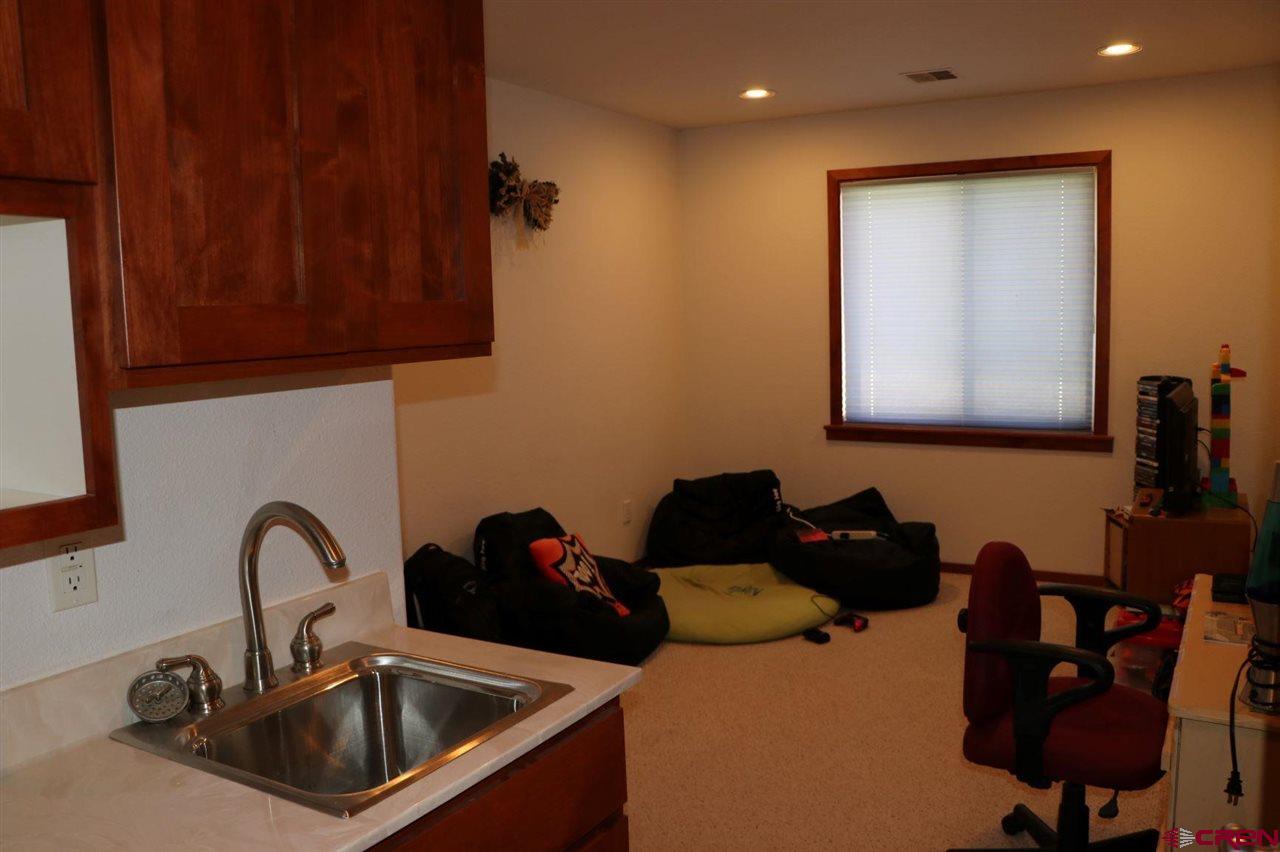 23720 County Rd M Cortez, CO 81321 - Photo 30 of 34 a kitchen with a sink and a stove top oven with wooden floor