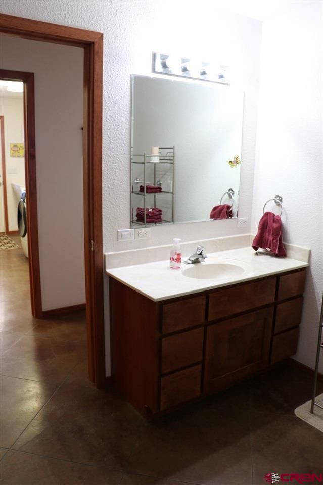 23720 County Rd M Cortez, CO 81321 - Photo 32 of 34 a bathroom with a sink vanity and a mirror