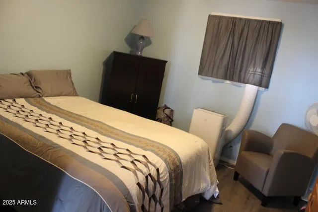 a bedroom with bed and wooden floor