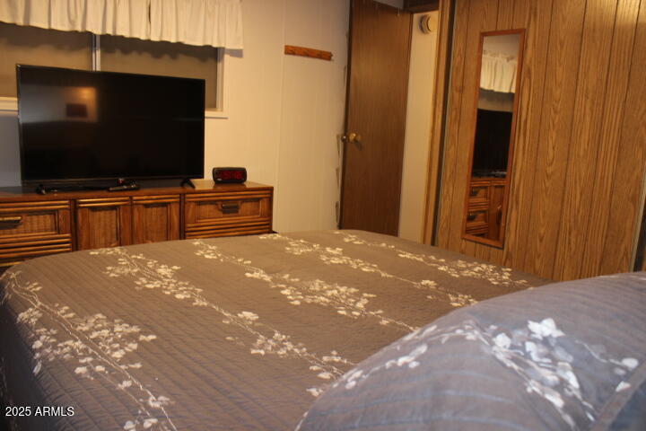 11425 East University Drive, Unit 63 Apache Junction, AZ 85120 - Photo 9 of 30 a bedroom with a bed and a flat screen tv