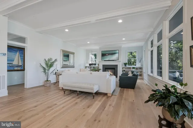 a living room with furniture large window and wooden floor