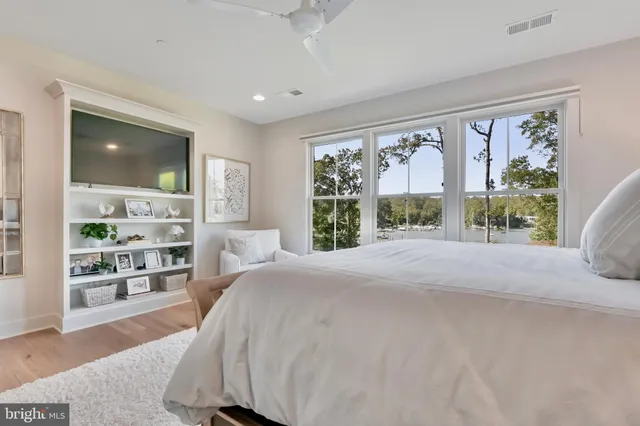 a bed sitting in a spacious bedroom next to a window