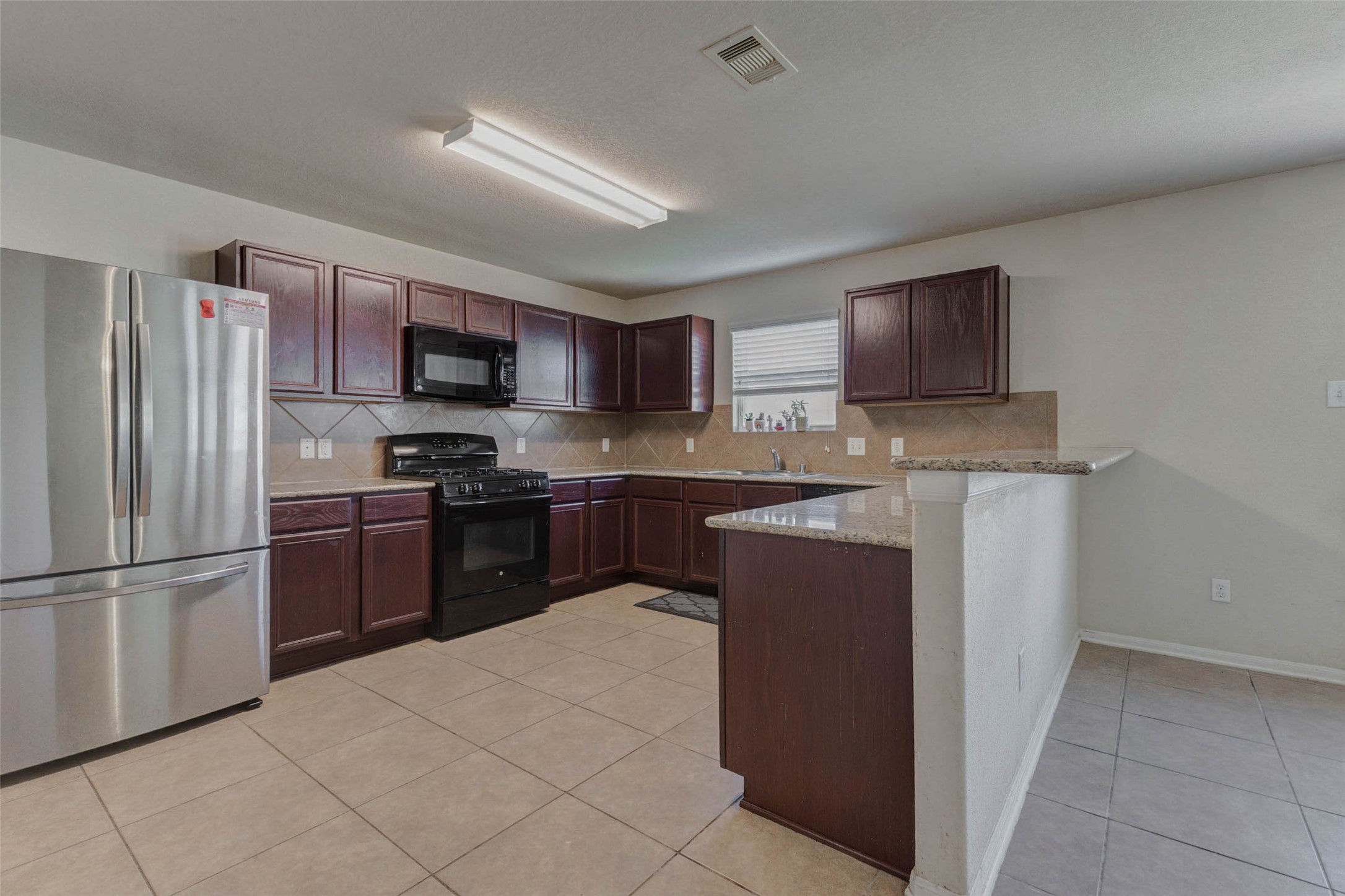 3027 Upland Spring Trace Katy, TX 77493 - Photo 7 of 29 a kitchen with stainless steel appliances granite countertop a refrigerator stove a sink and a microwave