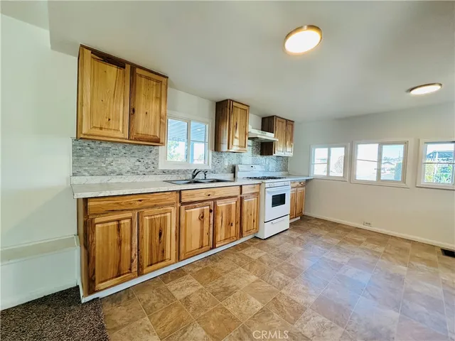 a kitchen with stainless steel appliances granite countertop a stove a sink and a microwave