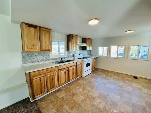 a large kitchen with stainless steel appliances granite countertop a sink and cabinets