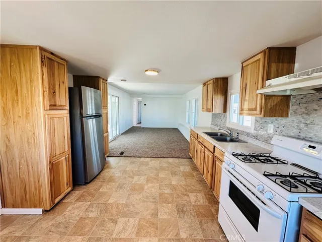 a kitchen with stainless steel appliances granite countertop a stove a sink and a refrigerator