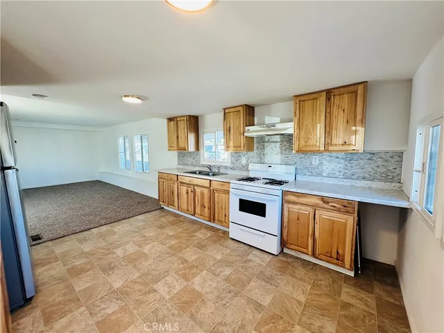 a kitchen with stainless steel appliances granite countertop a stove a sink and a refrigerator