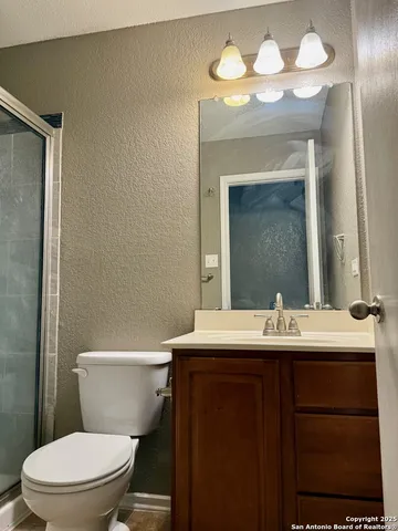 a bathroom with a sink a toilet and a mirror
