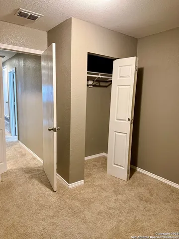 a view of empty room with refrigerator