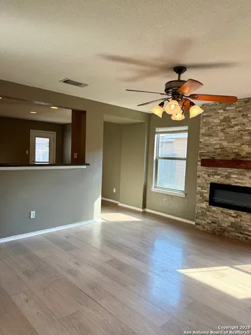 a view of an empty room with a window and wooden floor
