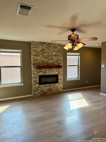 an empty room with windows and fireplace