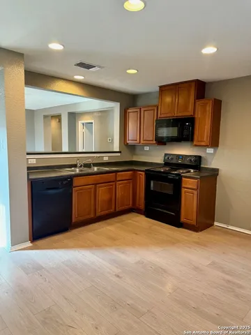 a large kitchen with stainless steel appliances granite countertop a stove sink and cabinets