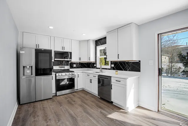 a kitchen with a refrigerator stove and white cabinets
