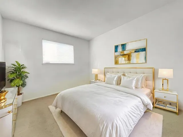 a bedroom with a bed and a potted plant