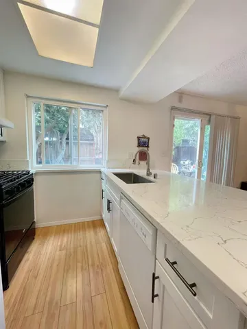 a kitchen with a sink and wooden floor