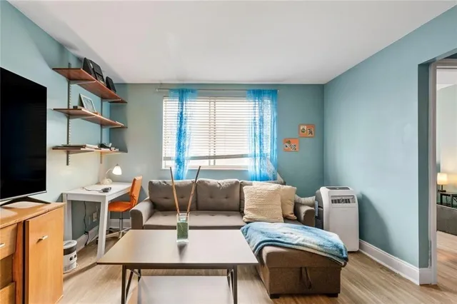 a living room with furniture a flat screen tv and a window