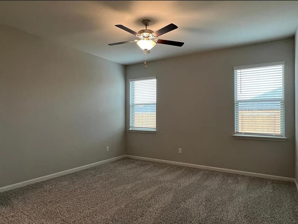 2013 Emma Court Anna, TX 75409 - Photo 12 of 20 Spacious room featuring neutral paint, textured carpet, two windows with blinds, a ceiling fan with integrated lighting, and white trim throughout