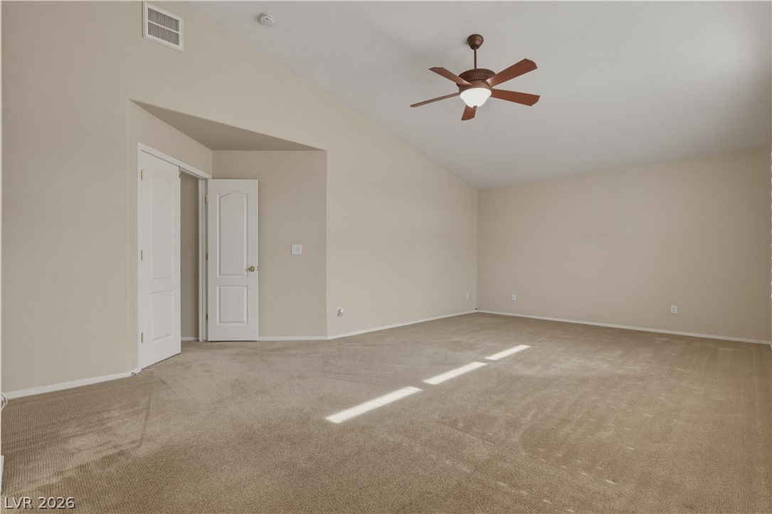 29 Olive Tree Henderson, NV 89074 - Photo 31 of 60 This spacious bedroom offers high vaulted ceilings and plush carpeting.