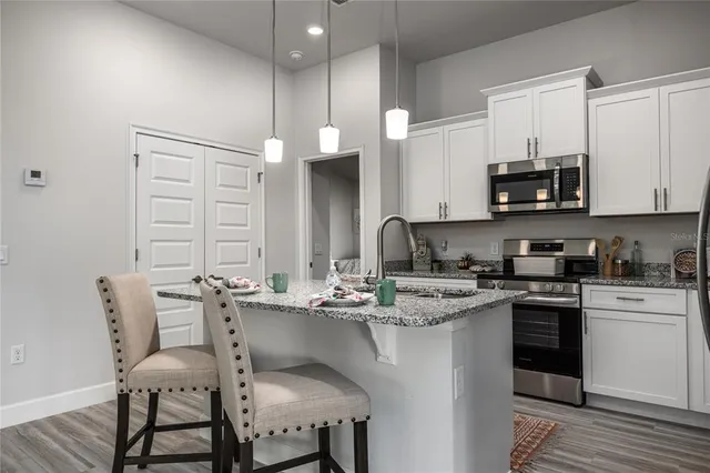a kitchen with a sink cabinets and wooden floor