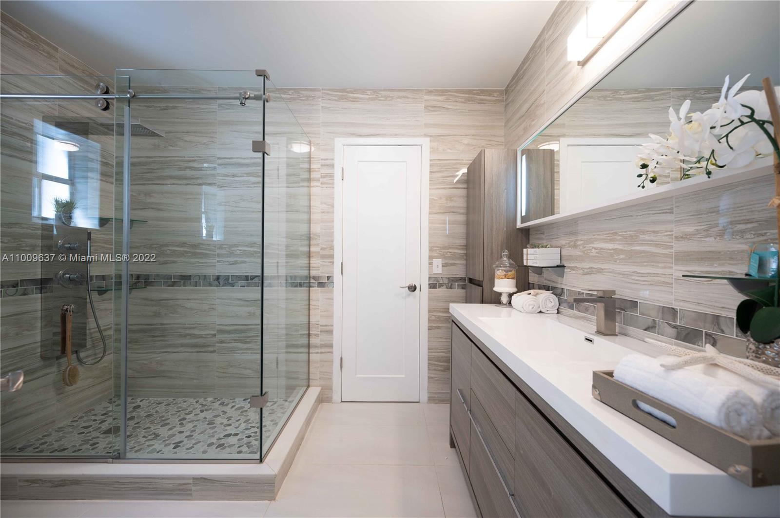 1700 Cleveland Road Miami Beach, FL 33141 - Photo 45 of 60 a bathroom with a shower sink and mirror