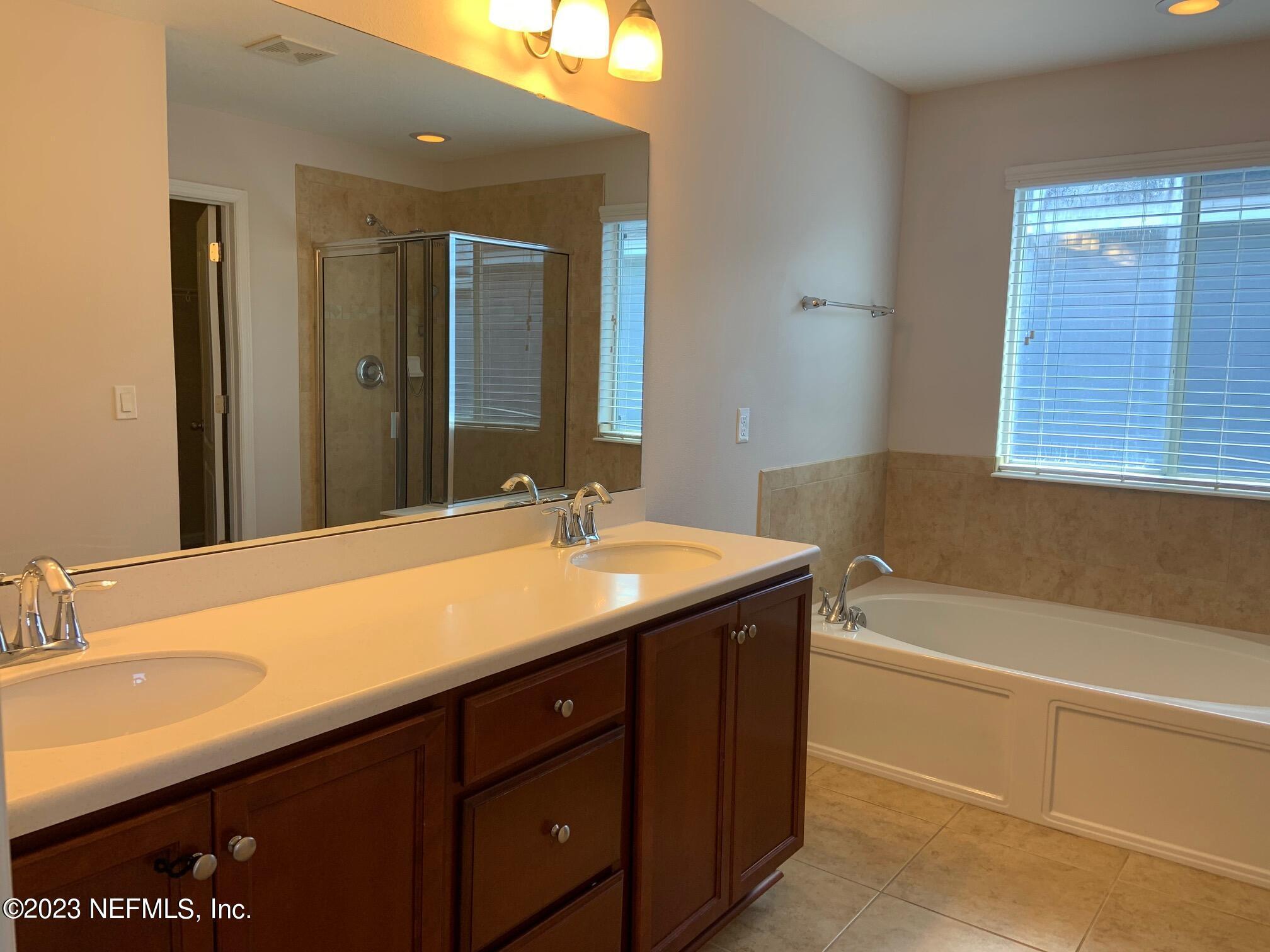 3863 Chasing Falls Road Orange Park, FL 32065 - Photo 22 of 32 a bathroom with a sink double vanity granite tub shower and a mirror
