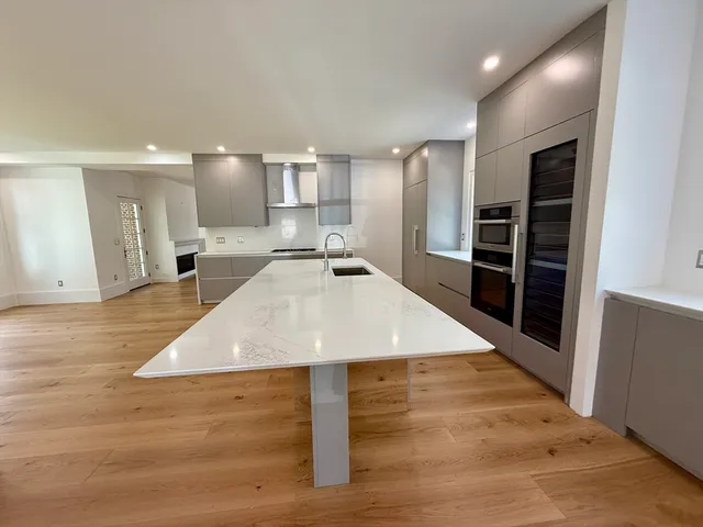 a large kitchen with kitchen island a sink stainless steel appliances and cabinets