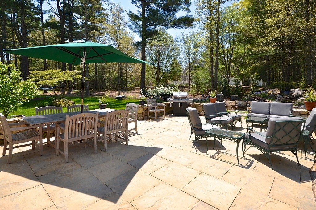 10 Holly Road Marion, MA 02738 - Photo 21 of 29 a view of a patio with a dining table and chairs under an umbrella