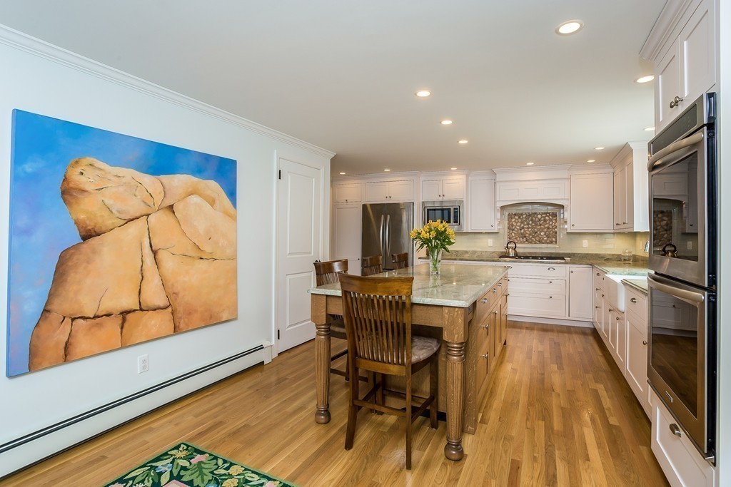 10 Holly Road Marion, MA 02738 - Photo 4 of 29 a kitchen with stainless steel appliances granite countertop a stove top oven a sink a dining table and chairs with wooden floor