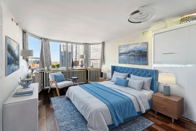 a bedroom with a bed a couch and large window