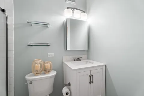 a bathroom with a toilet sink and mirror