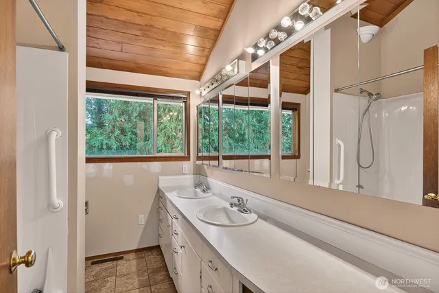 a bathroom with a granite countertop sink and a large mirror