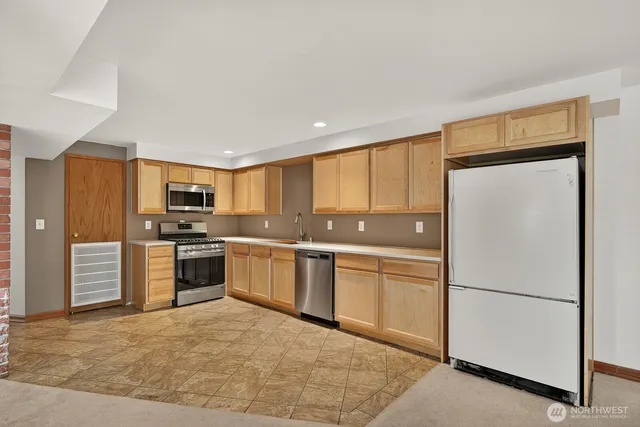 a kitchen with stainless steel appliances granite countertop a refrigerator sink and stove