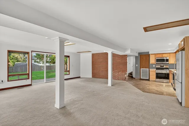 a view of an empty room with a fireplace and a large window
