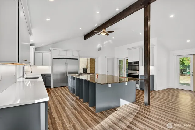 a kitchen with stainless steel appliances a refrigerator sink and microwave