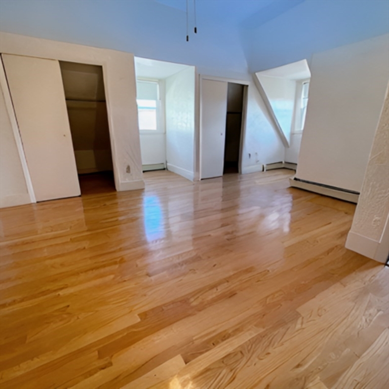 92 Thurston Street, Unit 3 Somerville, MA 02145 - Photo 2 of 10 an empty room with wooden floor and closet