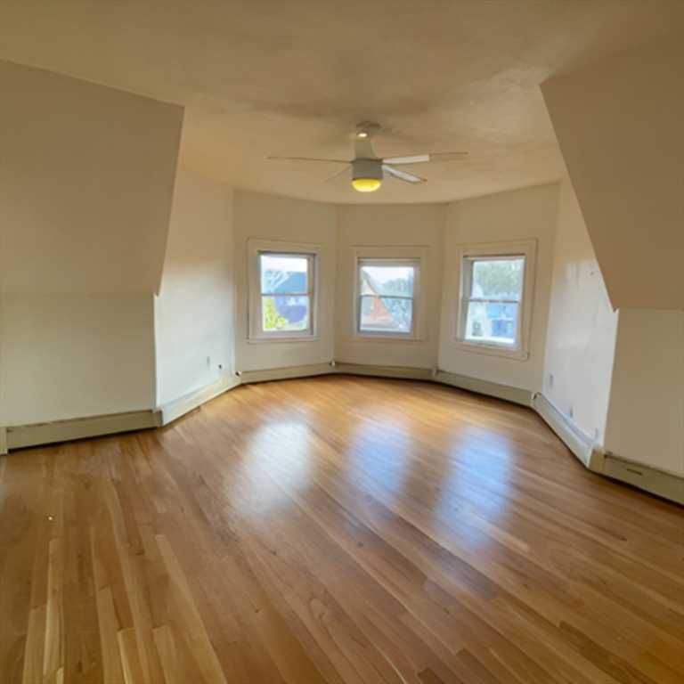 92 Thurston Street, Unit 3 Somerville, MA 02145 - Photo 4 of 10 a view of an empty room with wooden floor and a window