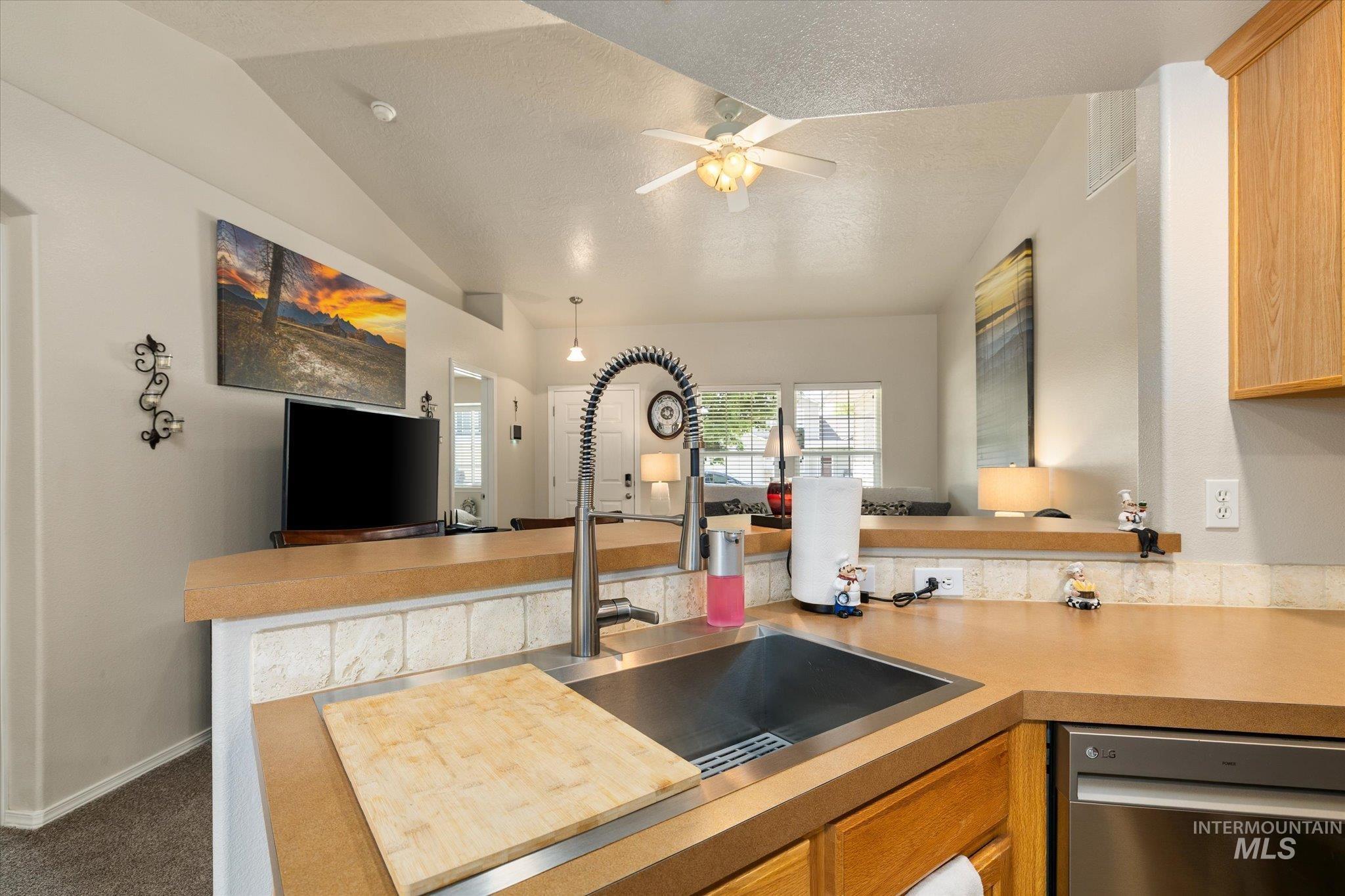 5401 Barkley Way Caldwell, ID 83607 - Photo 23 of 35 Kitchen featuring a stainless steel undermount sink with a gooseneck faucet, light wood-finish cabinetry, and a tile backsplash