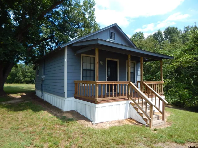 a view of a wooden house with a small yard