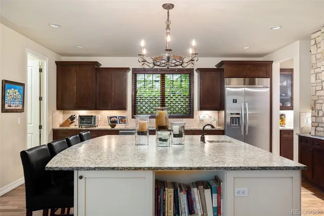 a kitchen with granite countertop a sink a center island stainless steel appliances and windows