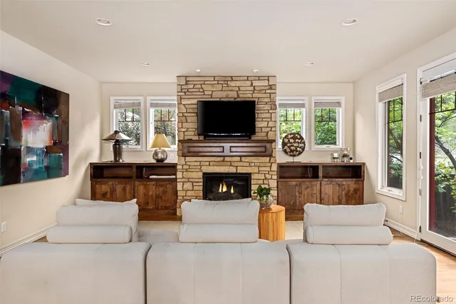 a living room with furniture a flat screen tv and a fireplace