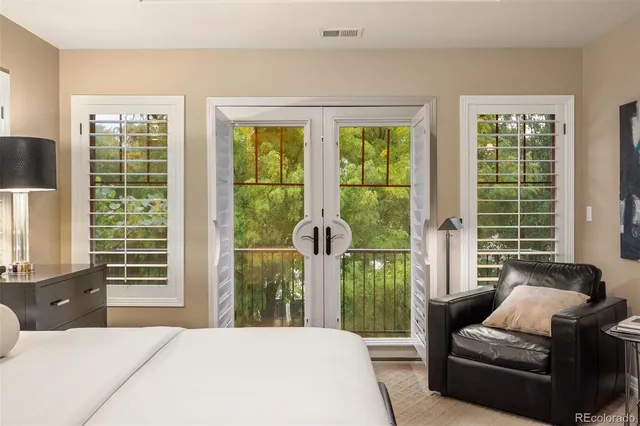 a bedroom with a bed a television and a large window