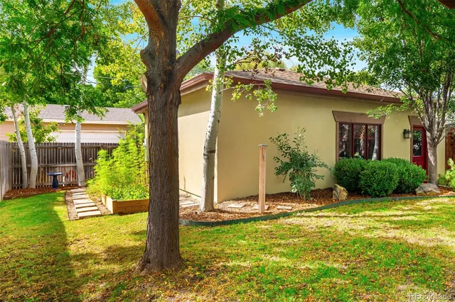 a patio with table and chairs with potted plants